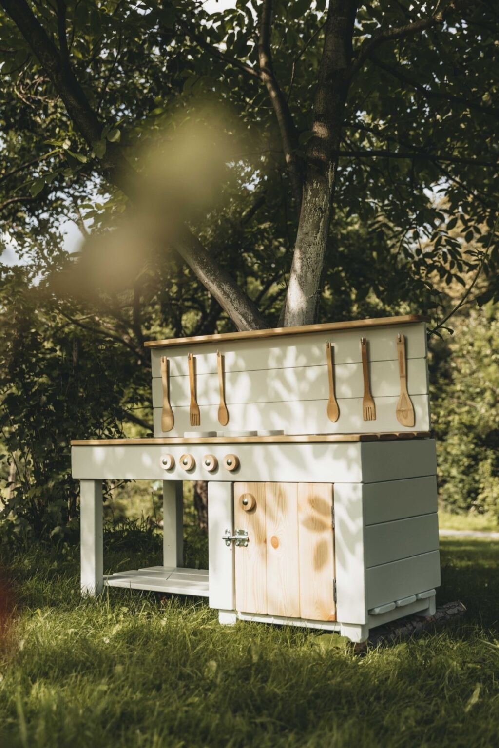 A compact cream mud kitchen in a small garden