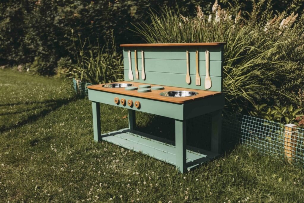 Handcrafted solid spruce wooden mud kitchen in a UK garden