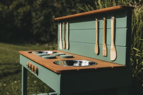 Hand-painted burners and wooden knobs on a mud kitchen worktop