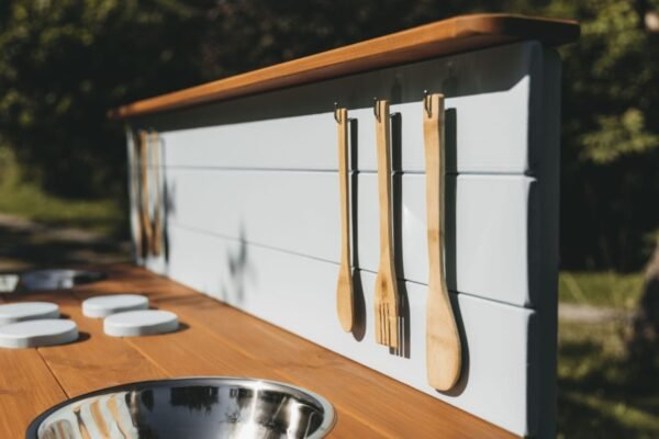 Wooden mud kitchen standing outdoors in wet weather
