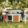Handcrafted solid spruce wooden mud kitchen in a UK garden
